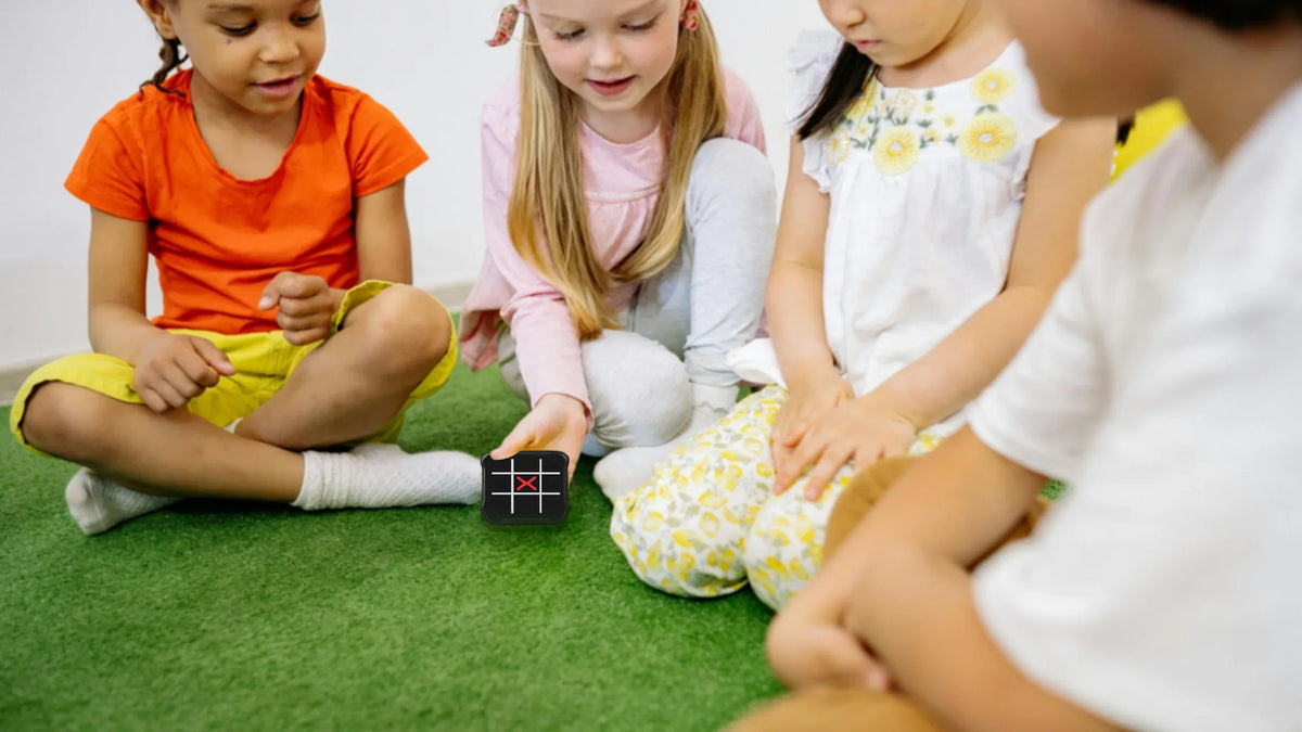 Techify™ electronic tic tac toe game shown in a lifestyle setting, with kids playing and enjoying interactive fun together
